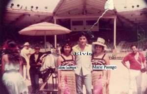 Elvis Presley filmed part of his 1966 movie, Paradise Hawaiian Style, at the Polynesian Cultural Center. Here he graciously poses with Marie Paongo and Suliana Lauhingoa.