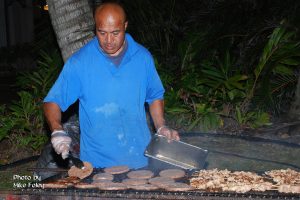 Employee worker grilling burger patties and barbecue