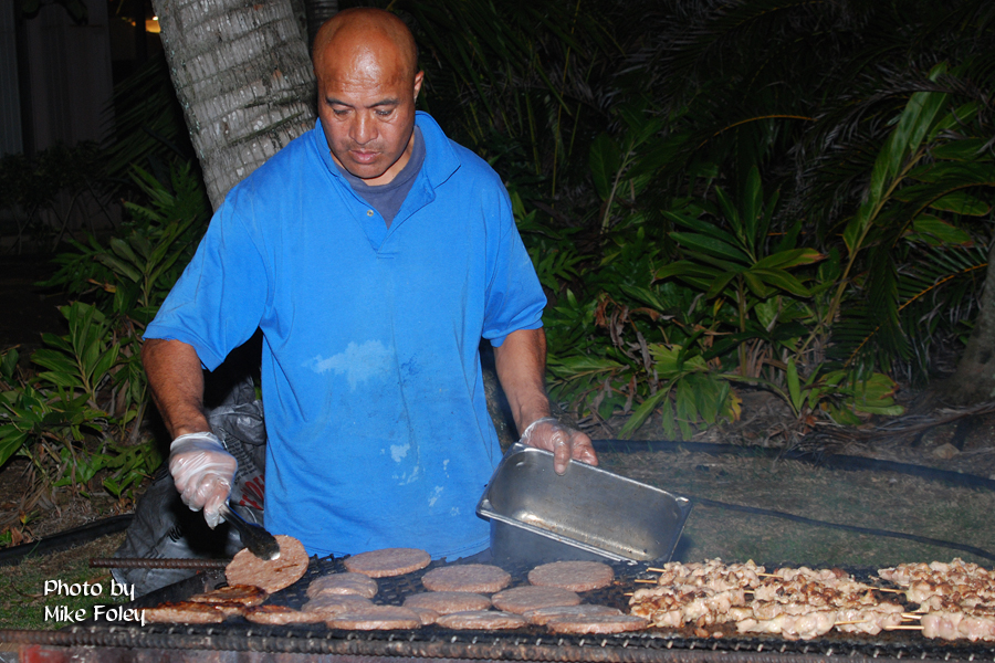 Employee worker grilling burger patties and barbecue